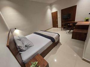 a bedroom with a bed and a desk and a television at KARIPPALS INN in Kottayam