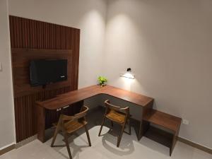 a wooden table with two chairs and a television at KARIPPALS INN in Kottayam +21 photos