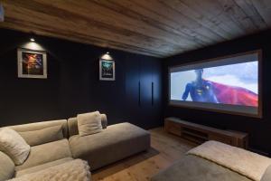 a living room with a couch and a big screen tv at Chalet Imperial by Altitudia in Morzine