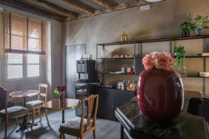 a room with a table and chairs and a kitchen at Dimora Del Teatro in Vigevano