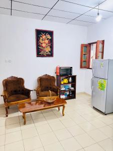 a living room with two chairs and a table and a refrigerator at Moragalla Relax Stay in Beruwala