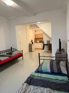a room with two beds and a kitchen in the background at Apartmani Ela 2 3 in Sierning