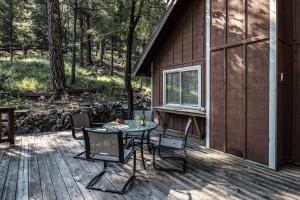 a patio with a table and chairs on a deck at RockInn Pines in Ruidoso