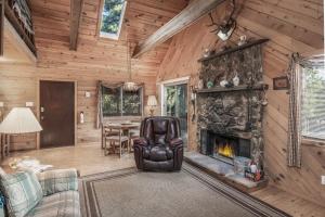 a living room with a fireplace in a log cabin at RockInn Pines in Ruidoso