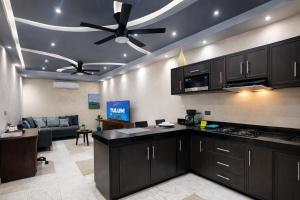 a kitchen with black cabinets and a ceiling fan at Kasa Nikte in Tulum