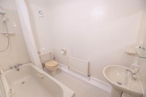 a bathroom with a tub and a toilet and a sink at Elim Bank Guest House in Windermere