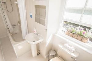 a bathroom with a sink and a toilet and a window at Elim Bank Guest House in Windermere +30 photos