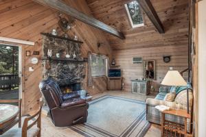 a living room with a stone fireplace in a cabin at RockInn Pines in Ruidoso