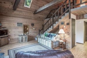 a living room with a couch and stairs at RockInn Pines in Ruidoso