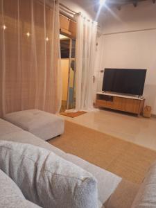 a living room with a flat screen tv and a couch at The Lighthouse Seaview Hotel in Rawai Beach