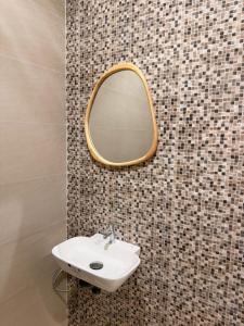 a bathroom with a sink and a mirror on a wall at AMIGOS Hostel El Nido in El Nido +21 photos