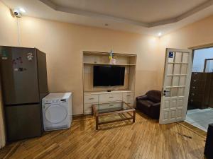 a living room with a flat screen tv and a washer at Хостел Палац Спорта in Kyiv
