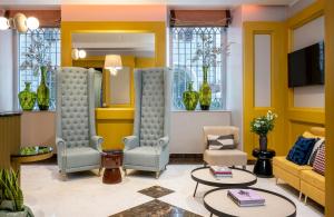ein Wohnzimmer mit zwei Sesseln und einem Fernseher in der Unterkunft Leonardo Boutique Hotel Rome Monti in Rom