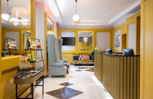 eine Lobby mit gelben Wänden und ein Wartezimmer in der Unterkunft Leonardo Boutique Hotel Rome Monti in Rom