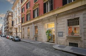 eine Straße, auf der Autos an der Seite eines Gebäudes geparkt sind in der Unterkunft Leonardo Boutique Hotel Rome Monti in Rom