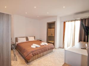 ein Schlafzimmer mit einem Bett mit zwei Handtüchern darauf in der Unterkunft PINEAPPLE Skiathos in Skiathos-Stadt