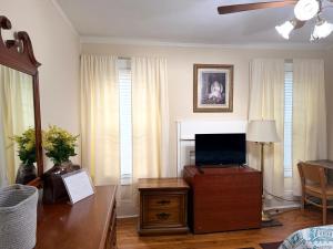 a living room with a tv on a wooden table at Brick House Retreat in Hamlet