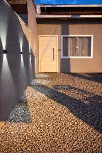 a building with a door and a gravel driveway at Studio Confortável no Centro com Garagem in Araquari