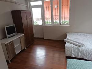 a bedroom with a bed and a tv and window at Dilara Hotel Pansiyon in Antalya +9 photos