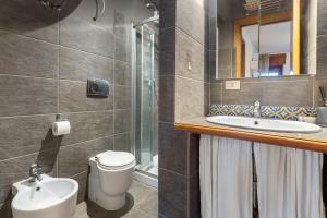 a bathroom with a sink and a toilet and a mirror at Hostdomus - Clotes 33 in Sauze d'Oulx +9 photos