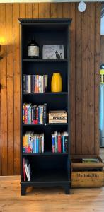 a black book shelf filled with books at Chalet Oasis - Your Alpine Hideaway in Bürglen +33 photos