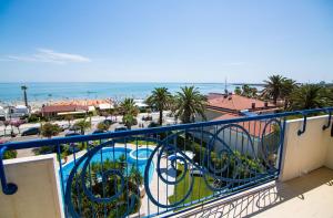 a balcony with a view of a pool and the ocean at Hotel Jerry - Beachfront & Private Pool in Grottammare