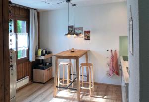 a kitchen with a table and two bar stools at Chalet Oasis - Your Alpine Hideaway in Bürglen
