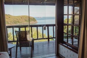a room with a balcony with a view of the ocean at Ilha de Toque Toque Eco Hotel in São Sebastião