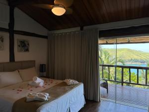 a bedroom with a bed and a large window at Ilha de Toque Toque Eco Hotel in São Sebastião