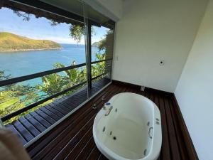 a bath tub in a room with a view of the ocean at Ilha de Toque Toque Eco Hotel in São Sebastião