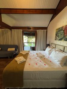 a bedroom with a large bed with red flowers on it at Ilha de Toque Toque Eco Hotel in São Sebastião +107 photos