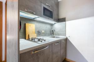 a kitchen with a sink and a tv on the wall at Hostdomus - Clotes 33 in Sauze d'Oulx