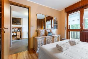 a bedroom with a bed and a mirror at Hostdomus - Clotes 33 in Sauze d'Oulx
