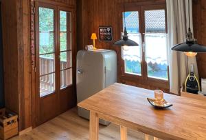 a dining room with a table and a refrigerator at Chalet Oasis - Your Alpine Hideaway in Bürglen