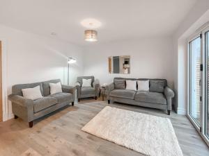 a living room with two couches and a rug at Eriska View in Port Appin