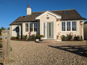 a white house with a gravel driveway at Rosegarth Bed and Breakfast in Marton