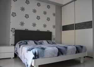 ein Schlafzimmer mit einem Bett und einer Wand mit Blumen in der Unterkunft Il Roseto di Daniela in Montefiascone