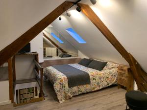a bedroom with a bed in a attic at JunoGîte - Résidence in Bernières-sur-Mer