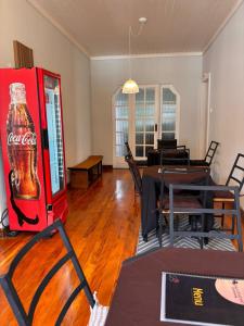 a cocacola soda machine in a living room with tables and chairs at Sollarium Pousada in Diamantina
