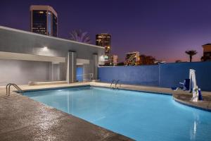 a swimming pool with a city skyline in the background at Holiday Inn Express & Suites Phoenix - Midtown, an IHG Hotel in Phoenix