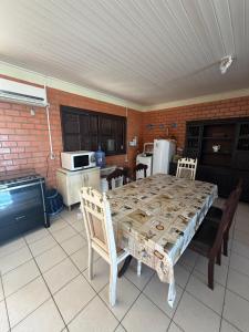 a kitchen with a table and chairs and a kitchen with a table and a table at Casa praia bella torres in Passo De Torres