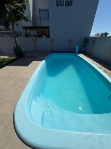 a large blue swimming pool next to a building at Casa praia bella torres in Passo De Torres