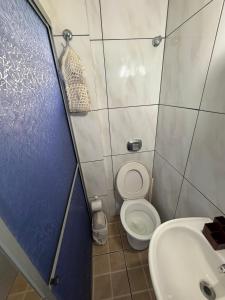 a small bathroom with a toilet and a sink at Casa praia bella torres in Passo De Torres +6 photos