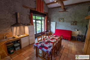a kitchen with a table with a red table cloth on it at Le Gîte de Saint Izaire in Saint-Izaire