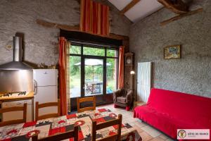 a living room with a red couch and a table at Le Gîte de Saint Izaire in Saint-Izaire