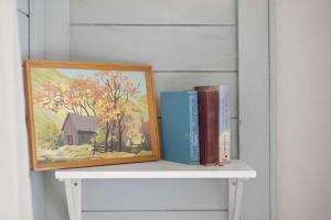 a shelf with two books and a painting on it at Camp Red Lodge - Cozy & Convenient in Red Lodge