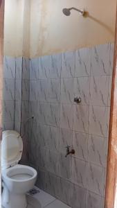 a bathroom with a toilet and a marble wall at Breezes home Bamburi in Bamburi