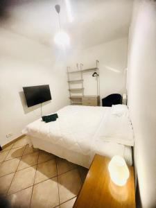 a bedroom with a white bed and a television at Mordano Apartment - ampio appartamento SELF CHECK-IN vicino a Imola in Mordano