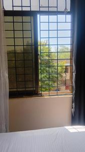 a bedroom with a bed and a window with a view at Breezes home Bamburi in Bamburi