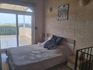 a bedroom with a bed and a large window at Sunsets Farmhouse, Nadur Gozo in Nadur +33 photos